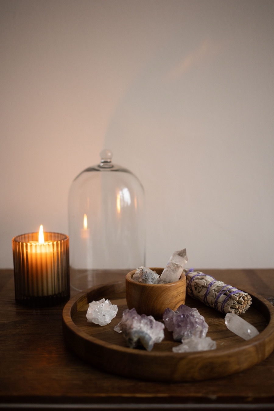 Candle, crystals and sage on a wooden tray